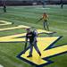 Temporary grounds crew member Jordan Lerch uses a leaf blower on the astroturf. Daniel Brenner I AnnArbor.com